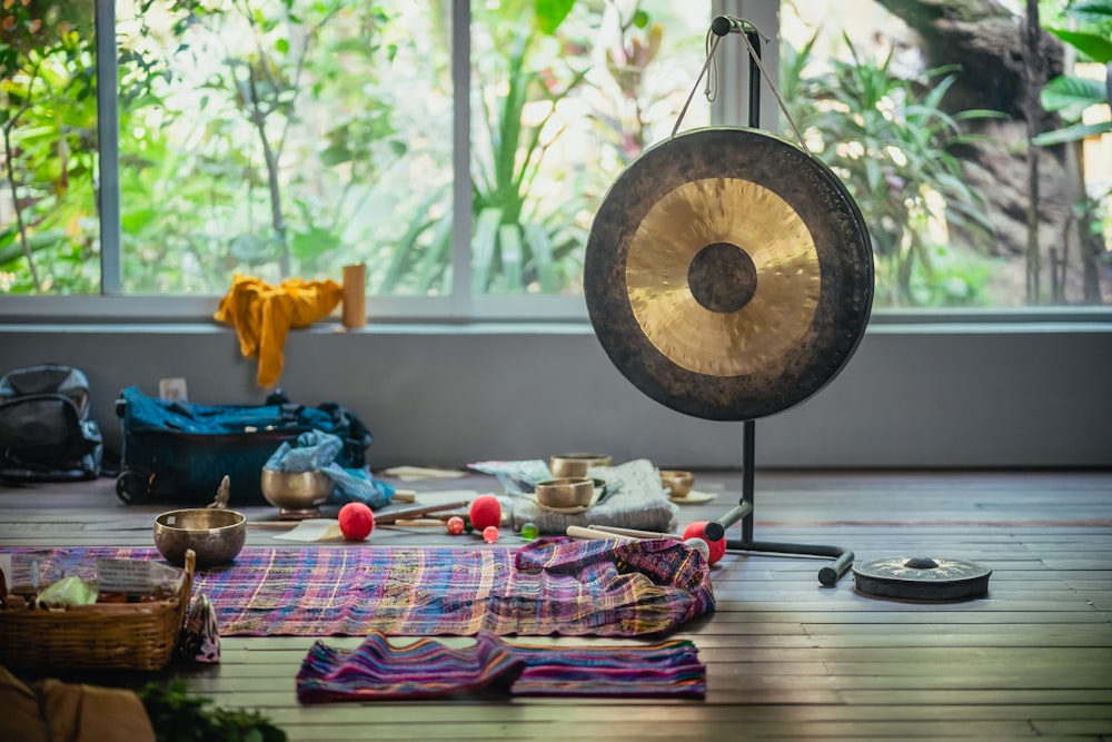 a gong sitting on top of a wooden floor next to a window