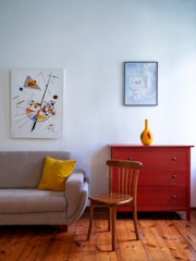 Freshly painted cozy living room with soft yellow accent wall and charcoal grey trim.