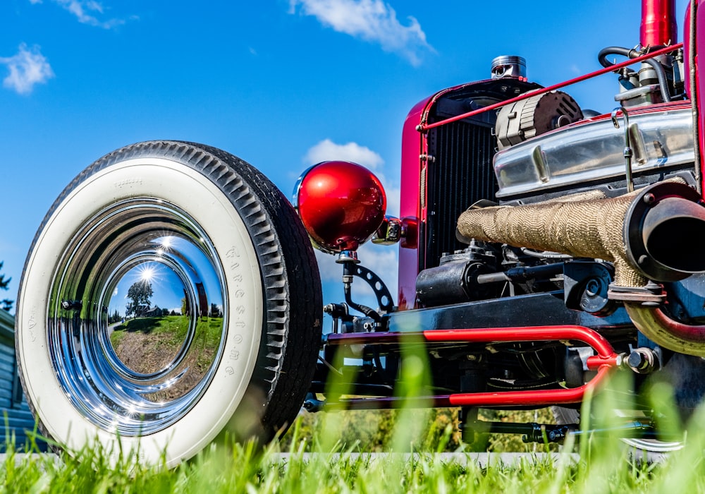 a close up of a red and white tractor in the grass