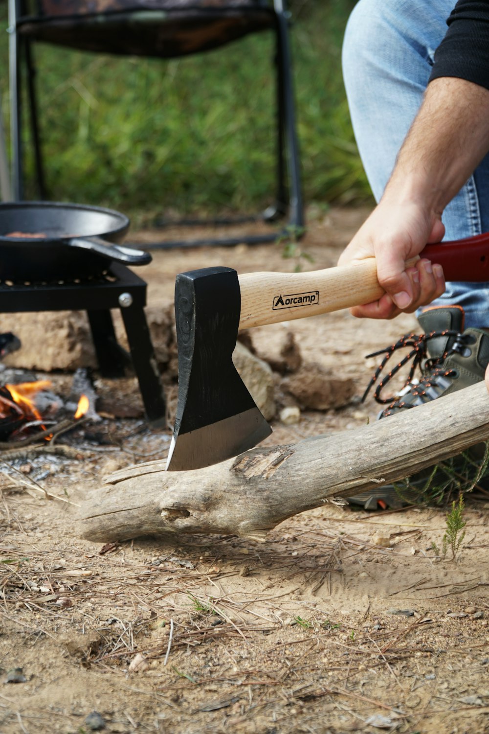 a man holding an axe over a piece of wood