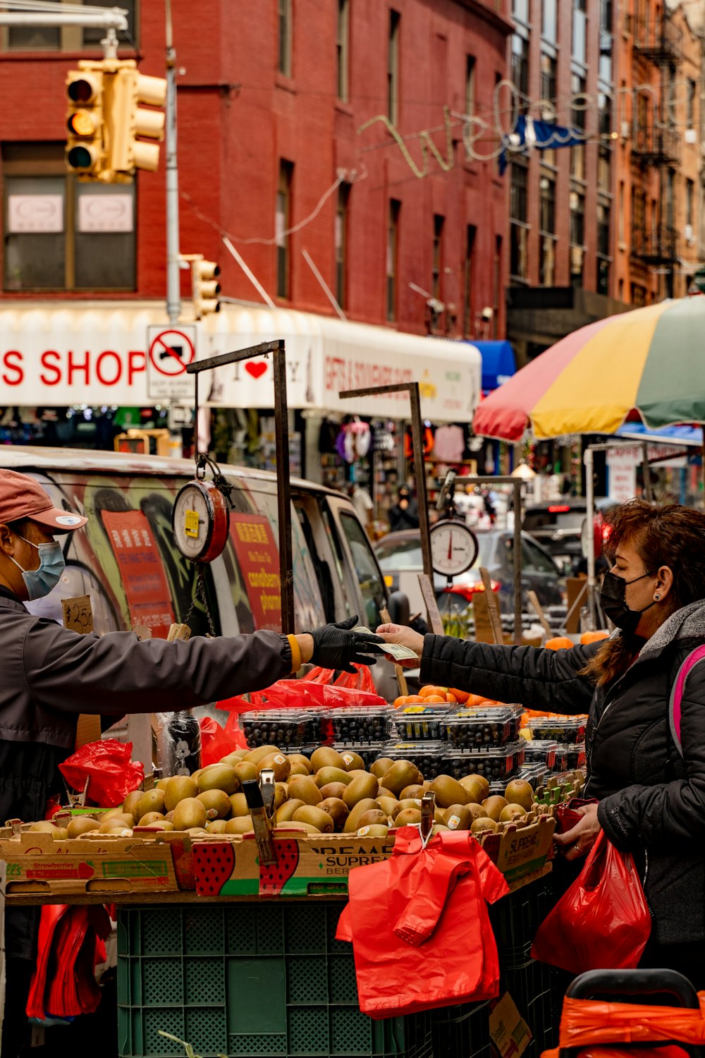 a man and a woman standing in front of a fruit stand