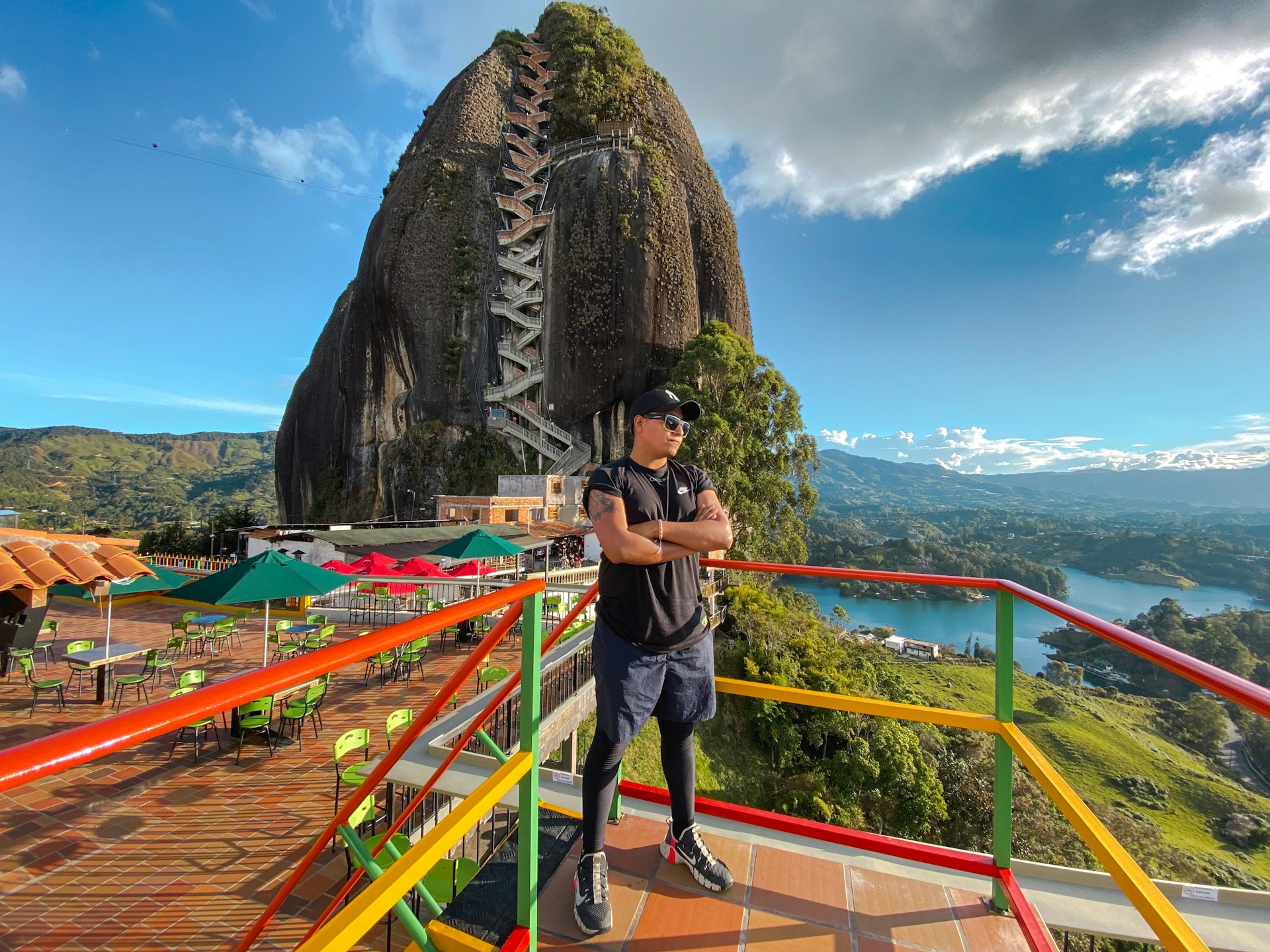 a man standing on top of a balcony next to a mountain