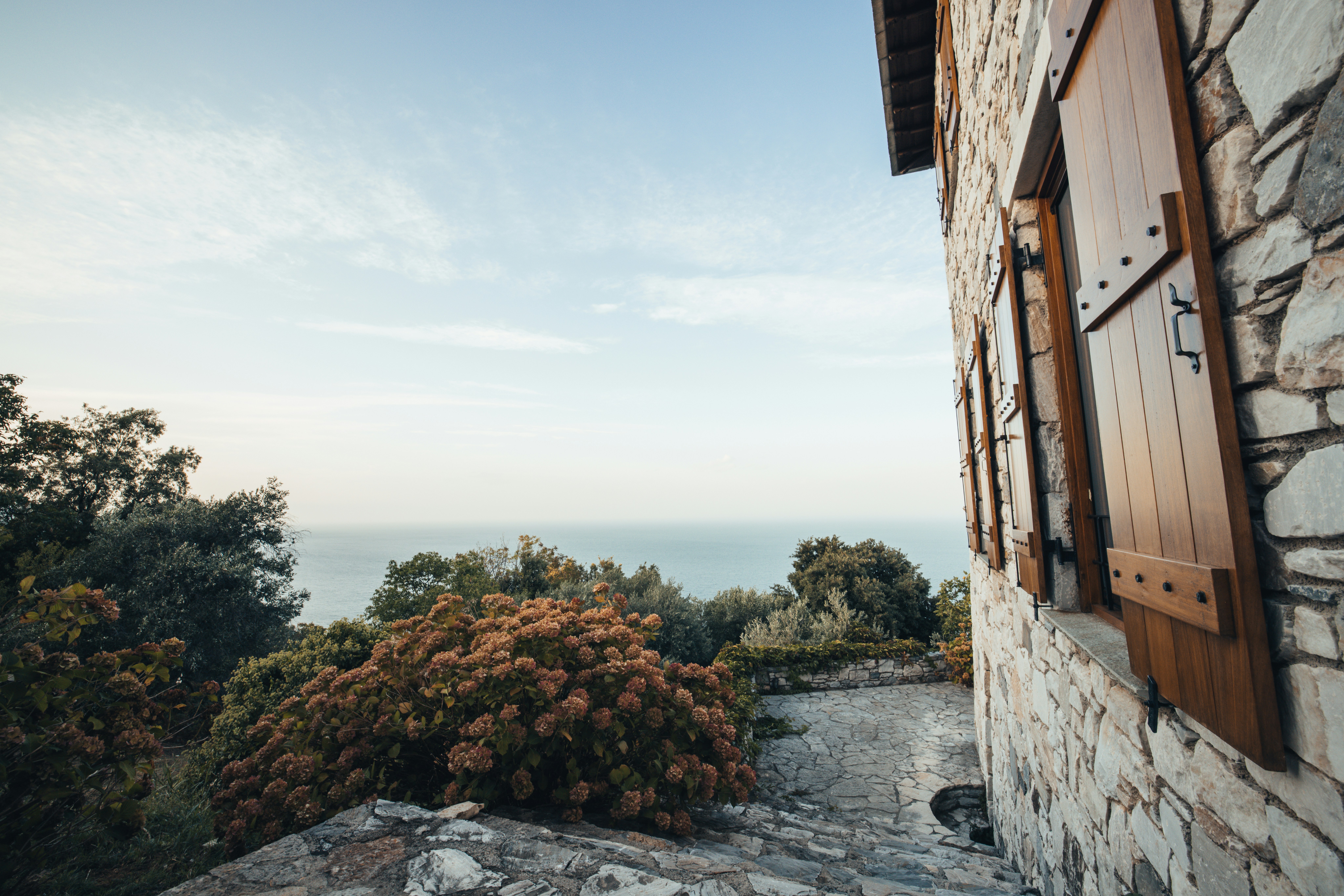 a window on a stone building with a view of the ocean