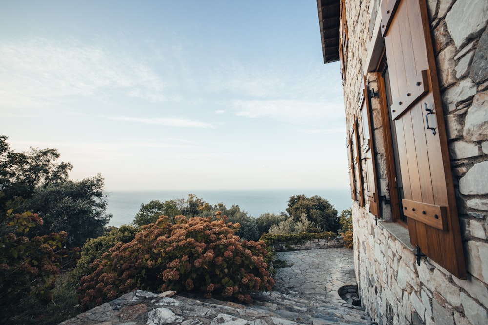 a window on a stone building with a view of the ocean