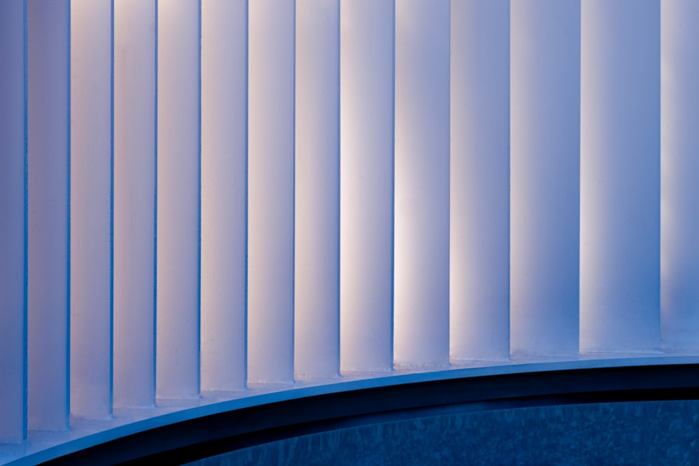 a close up of a curved wall with vertical blinds