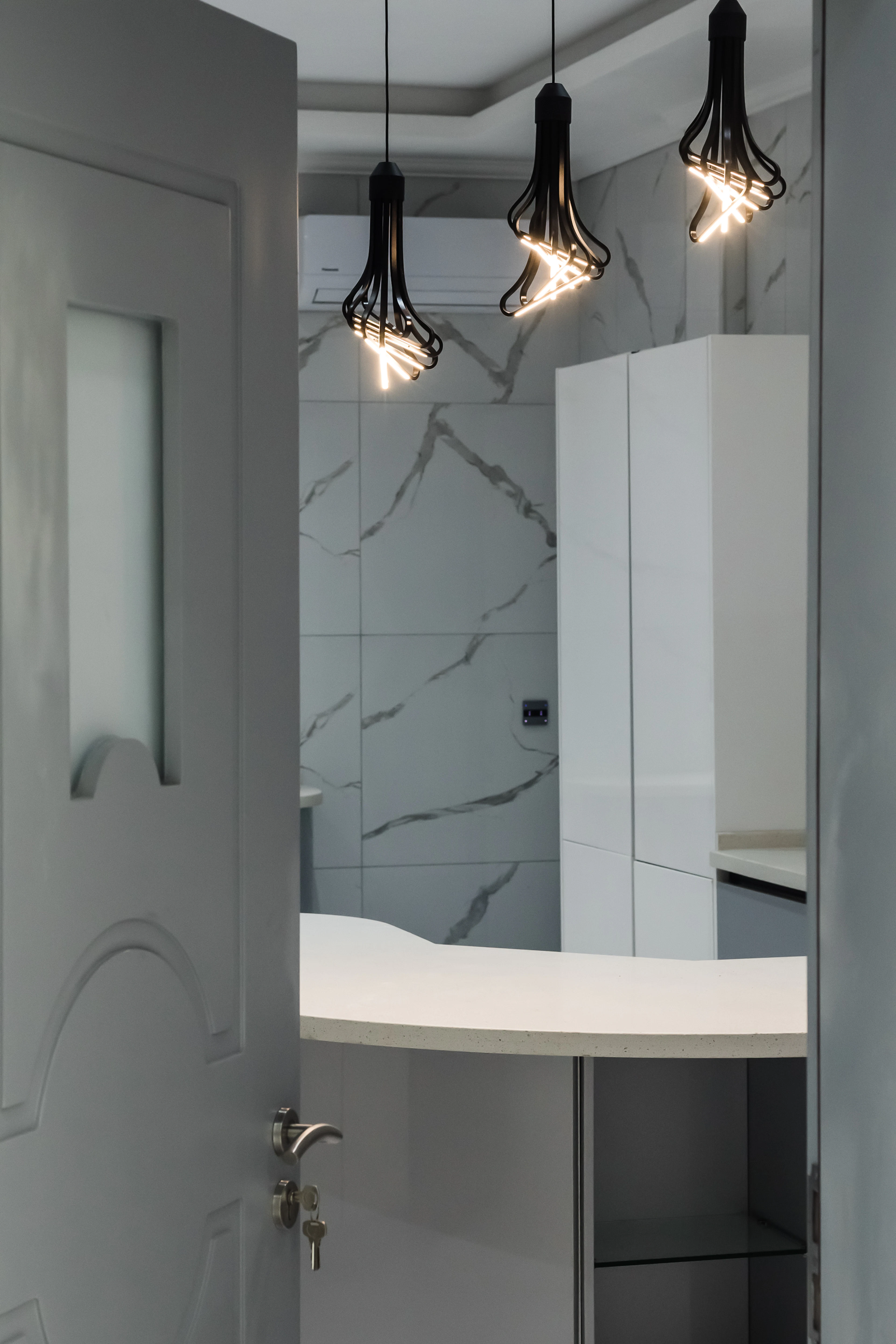 Bathroom with marble walls and a white vanity