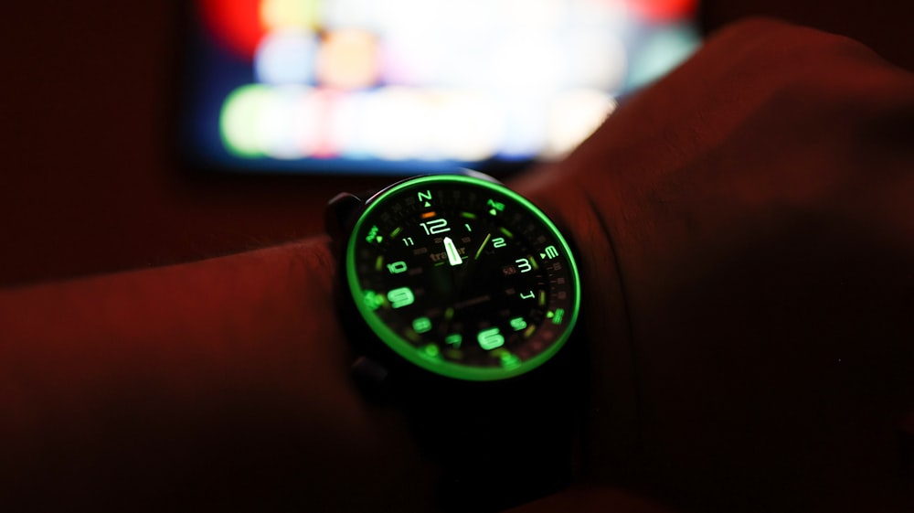 a watch that is glowing green in the dark