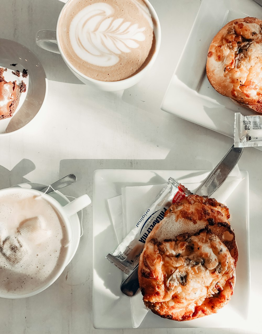 a table topped with plates of food and cups of coffee