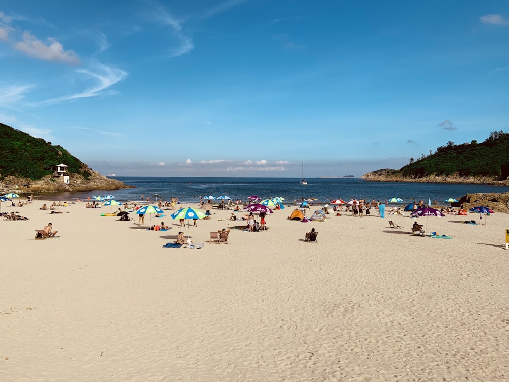 a group of people sitting on top of a sandy beach