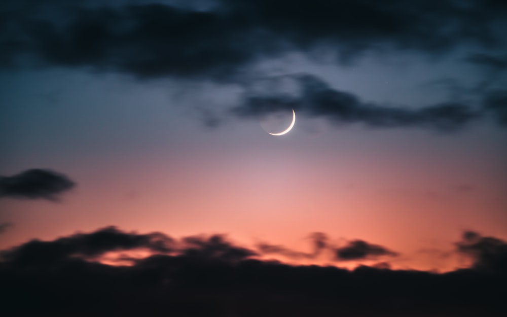 a crescent is seen in the night sky