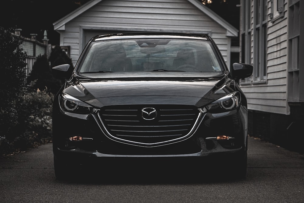 a black car parked in front of a house