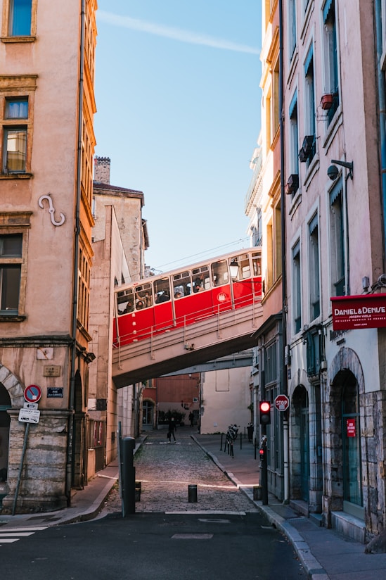 a red train traveling over a bridge over a street