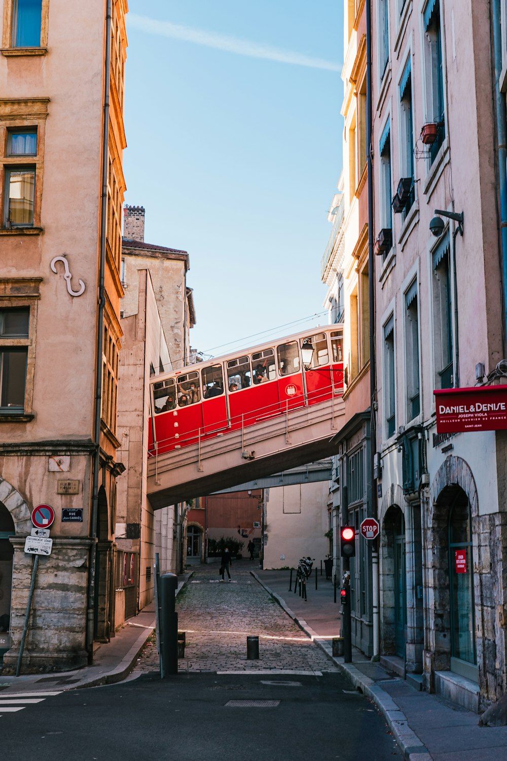 a red train traveling over a bridge over a street