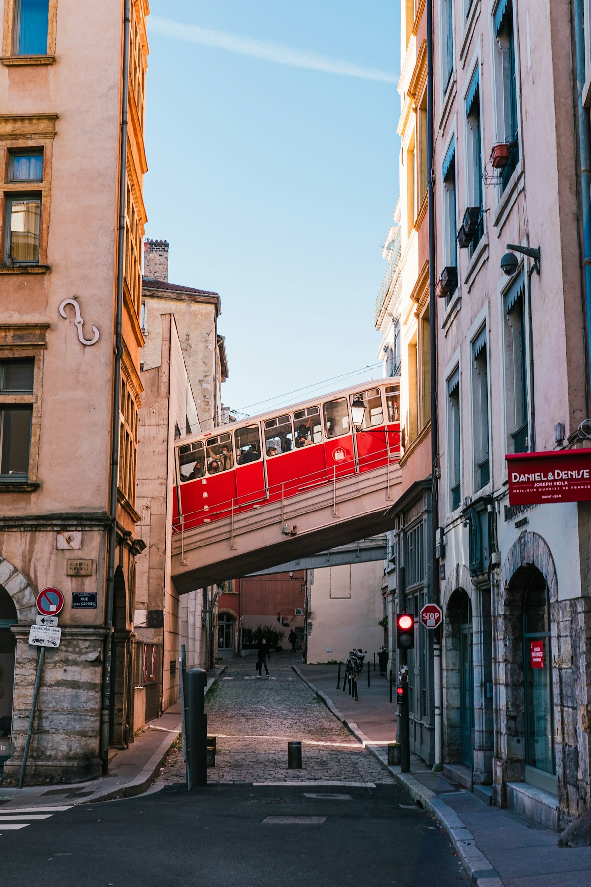 Red cable car crossing a bridge above the streets of Vieux Lyon historic district