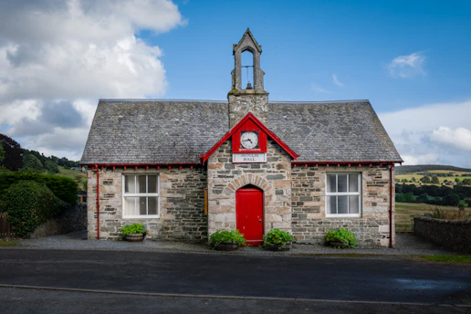 a small stone building with a clock on the front
