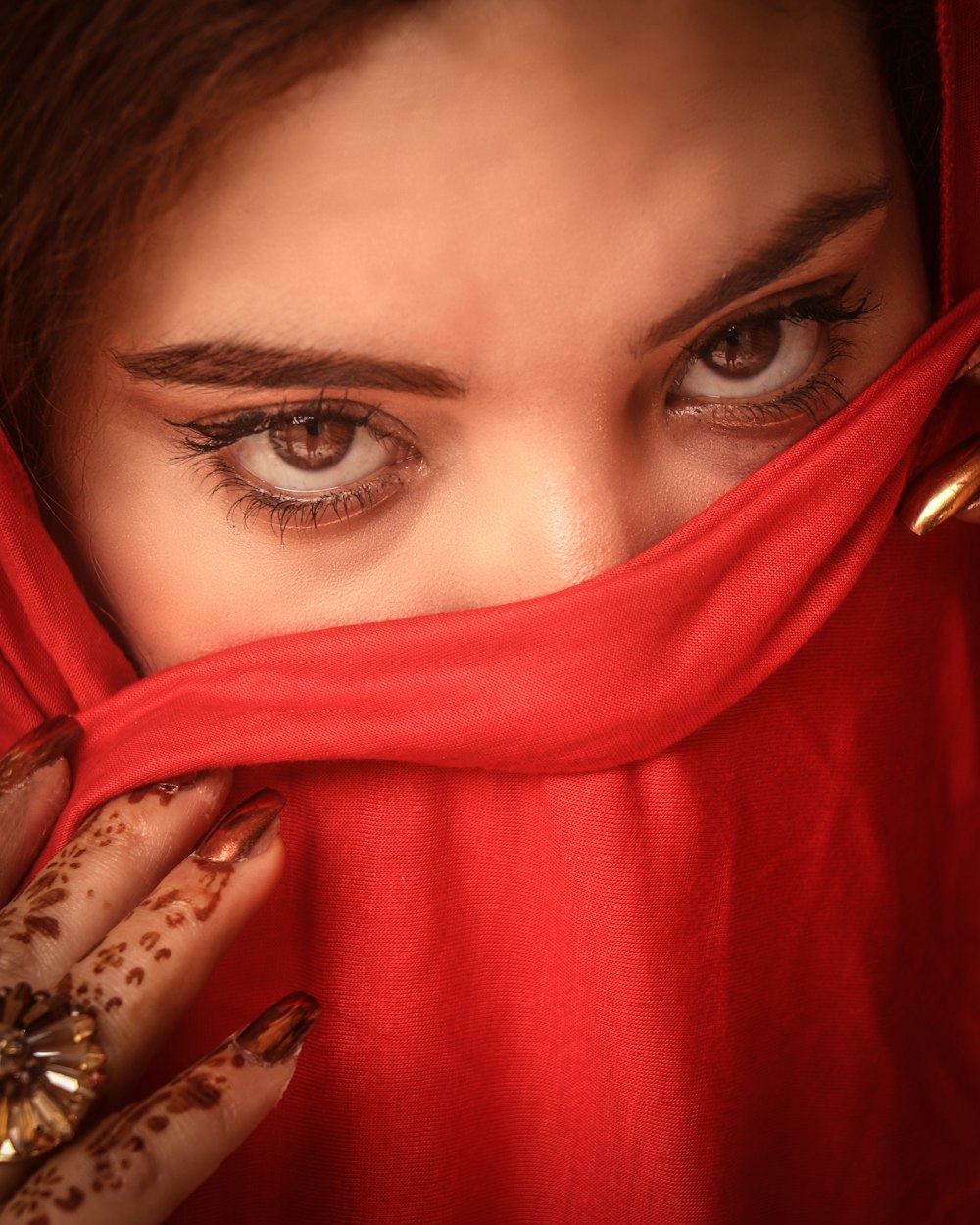 a close up of a person wearing a red veil
