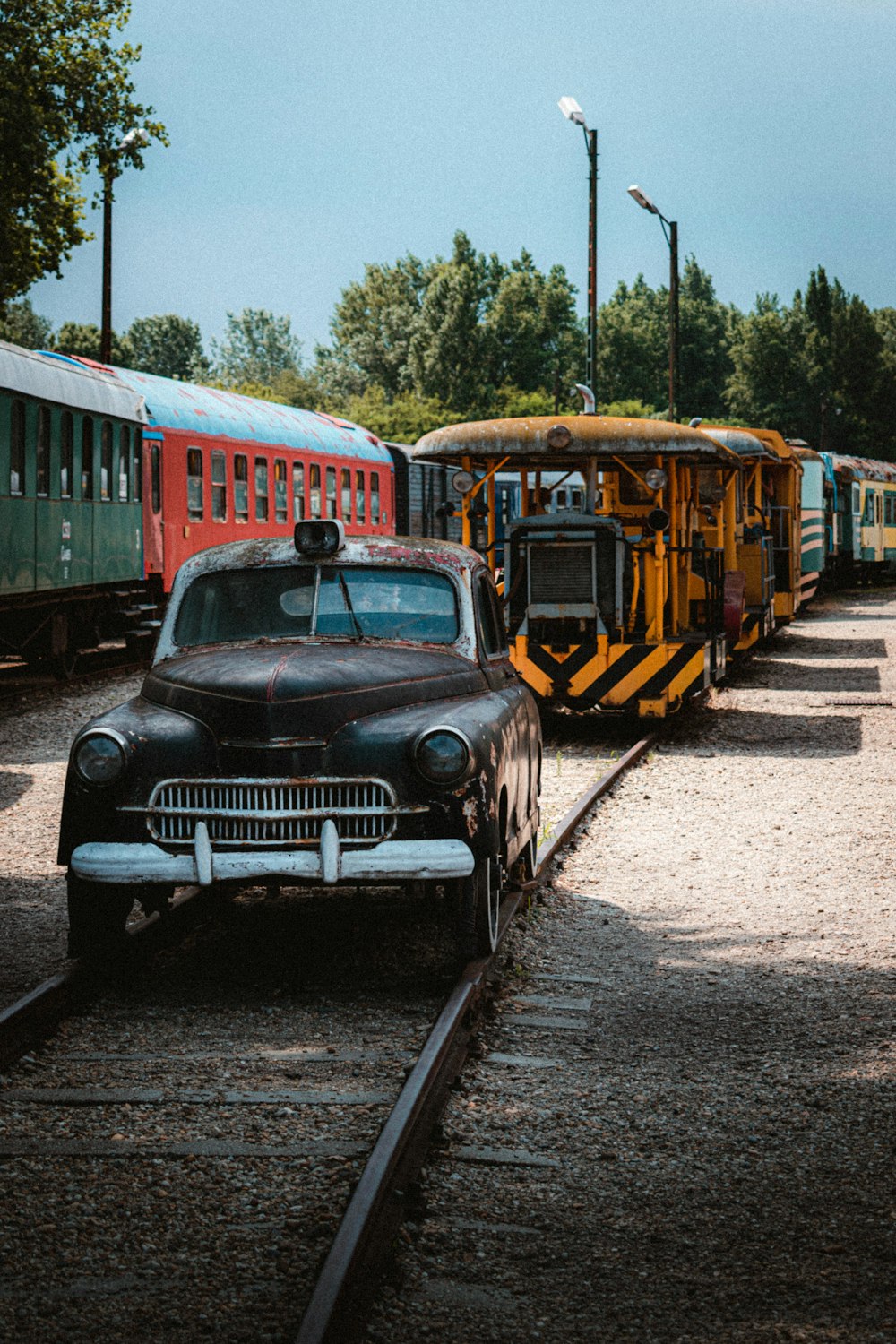 an old car is parked next to a train