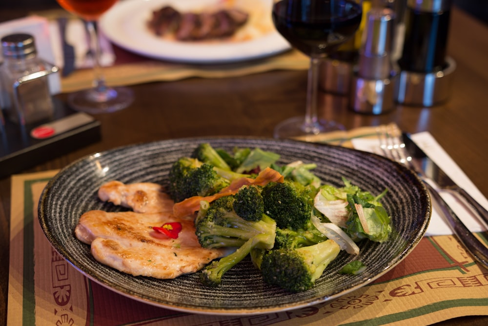 a plate of broccoli and chicken on a table