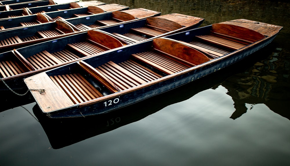 eine Reihe von Holzbooten, die auf einem Gewässer schwimmen