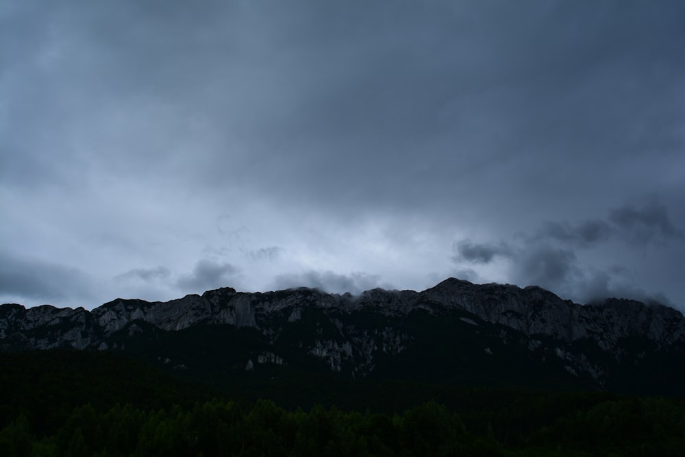 a dark sky with a mountain in the background