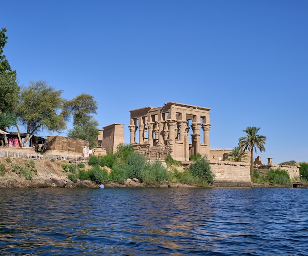 a large building sitting on top of a cliff next to a body of water