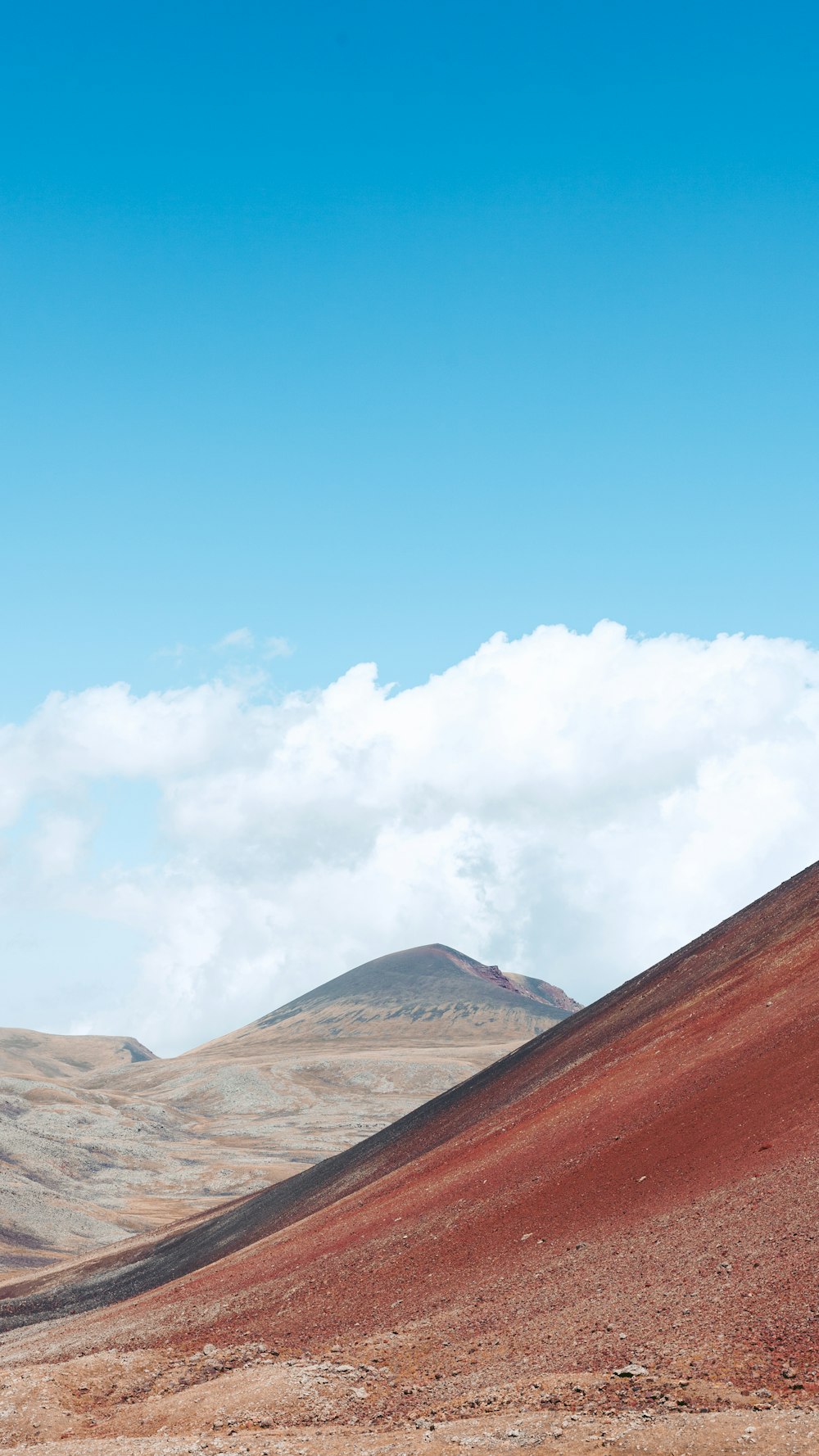 a hill with a few clouds in the sky