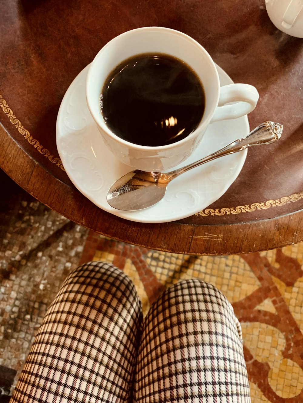 a cup of coffee sitting on top of a wooden table