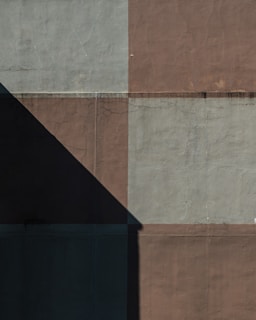 the shadow of a clock on the side of a building