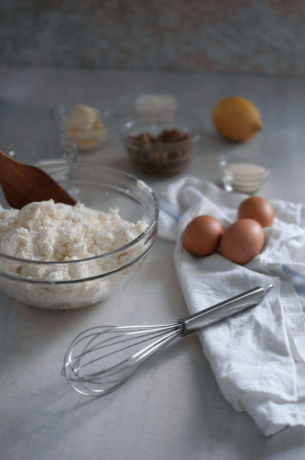 a table topped with a bowl of food and a whisk