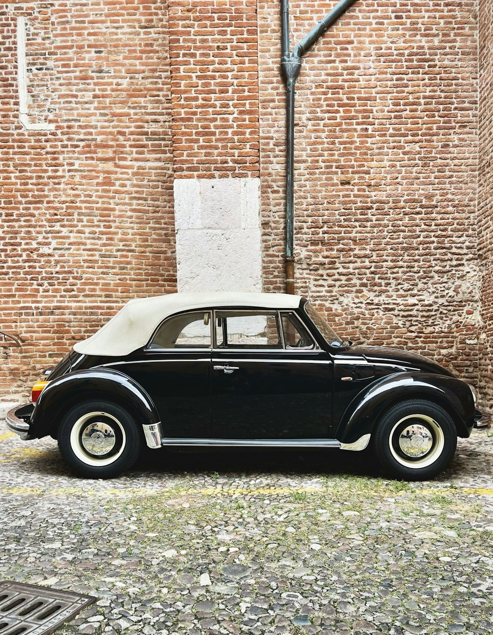 a black car parked in front of a brick building