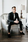 a man in a suit sitting on a chair