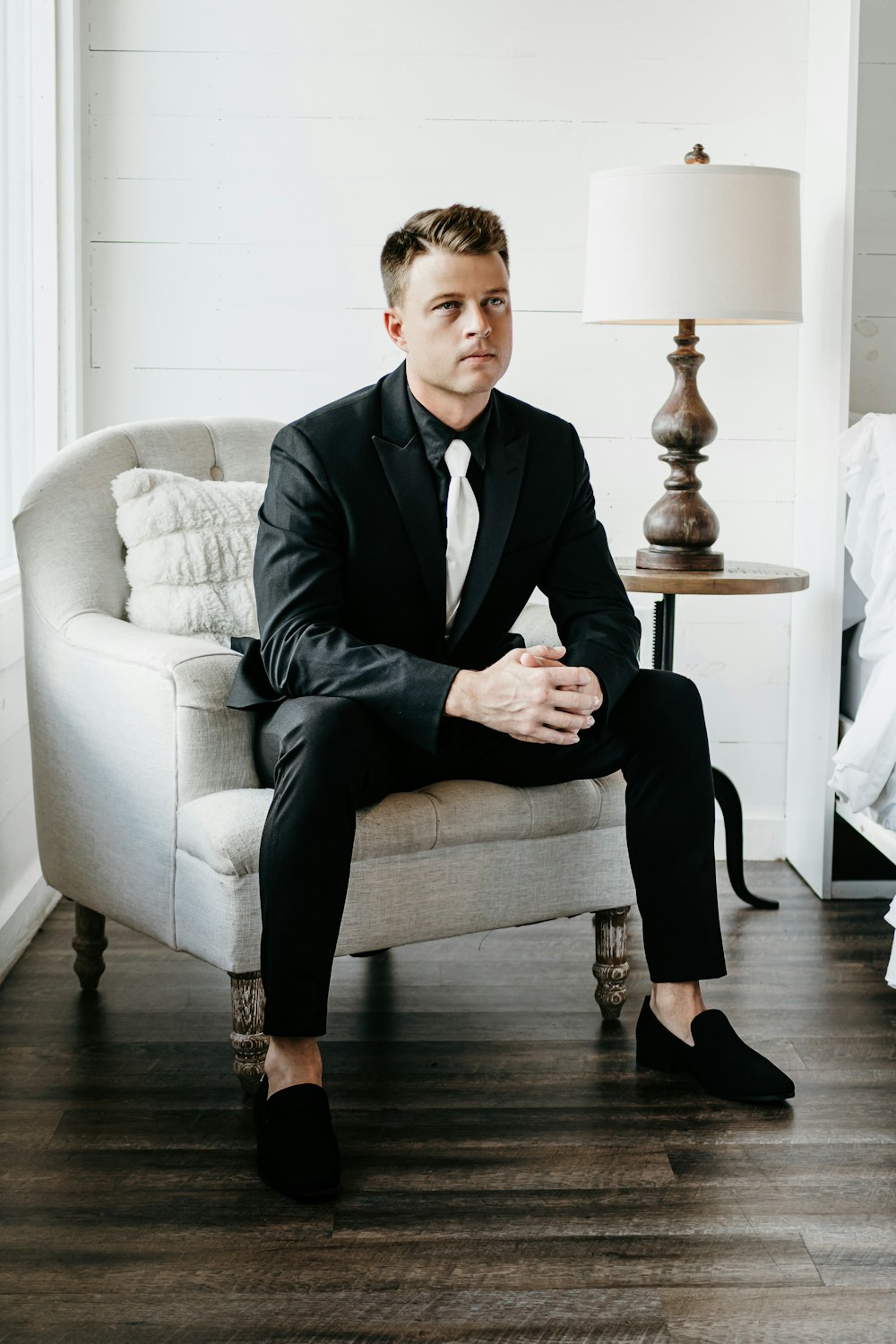 a man in a suit sitting on a chair