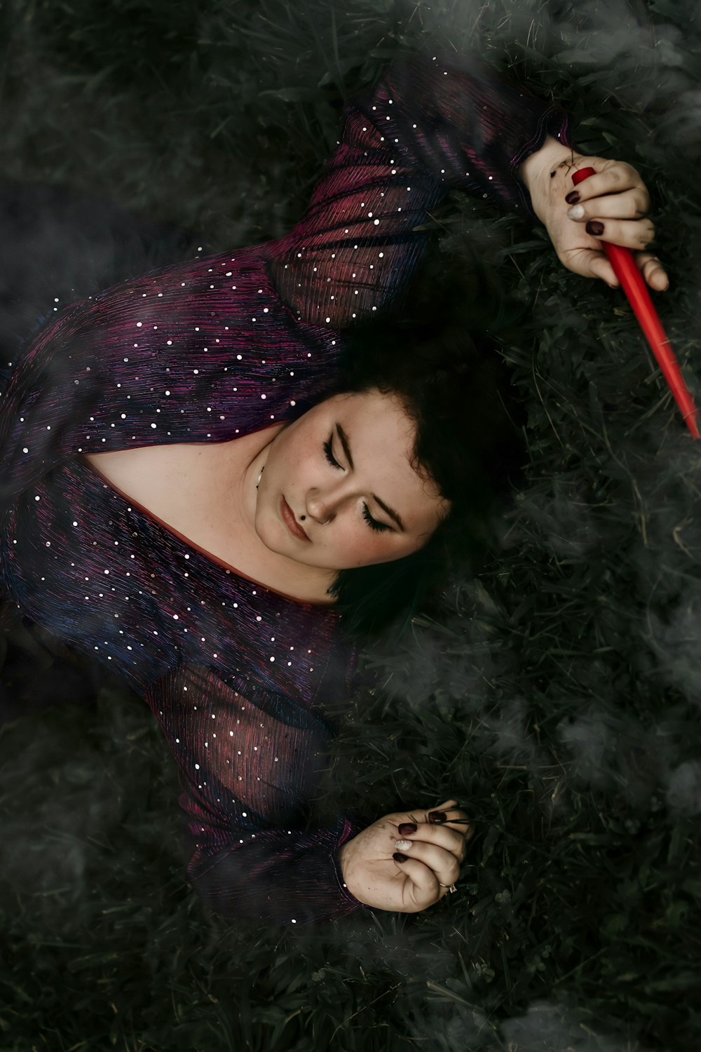 a woman in a purple dress holding a red stick