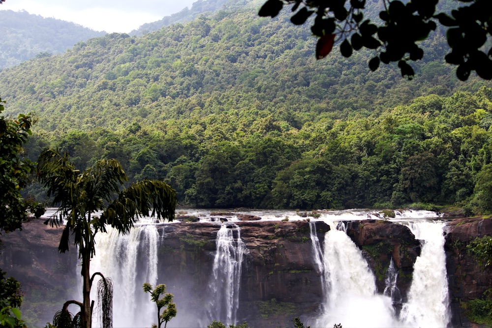 a large waterfall surrounded by lush green trees