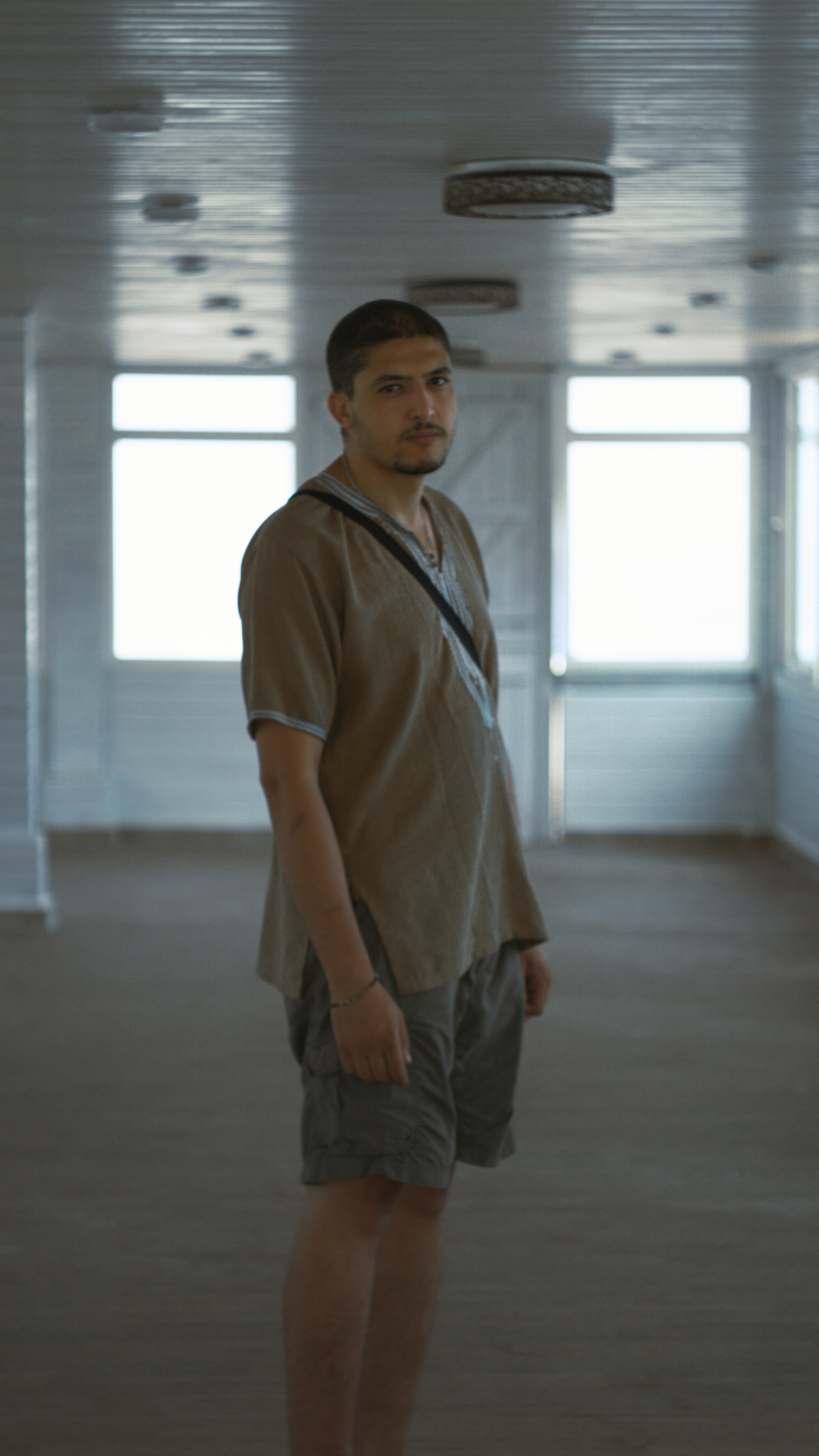 a man standing in a room with a camera around his neck