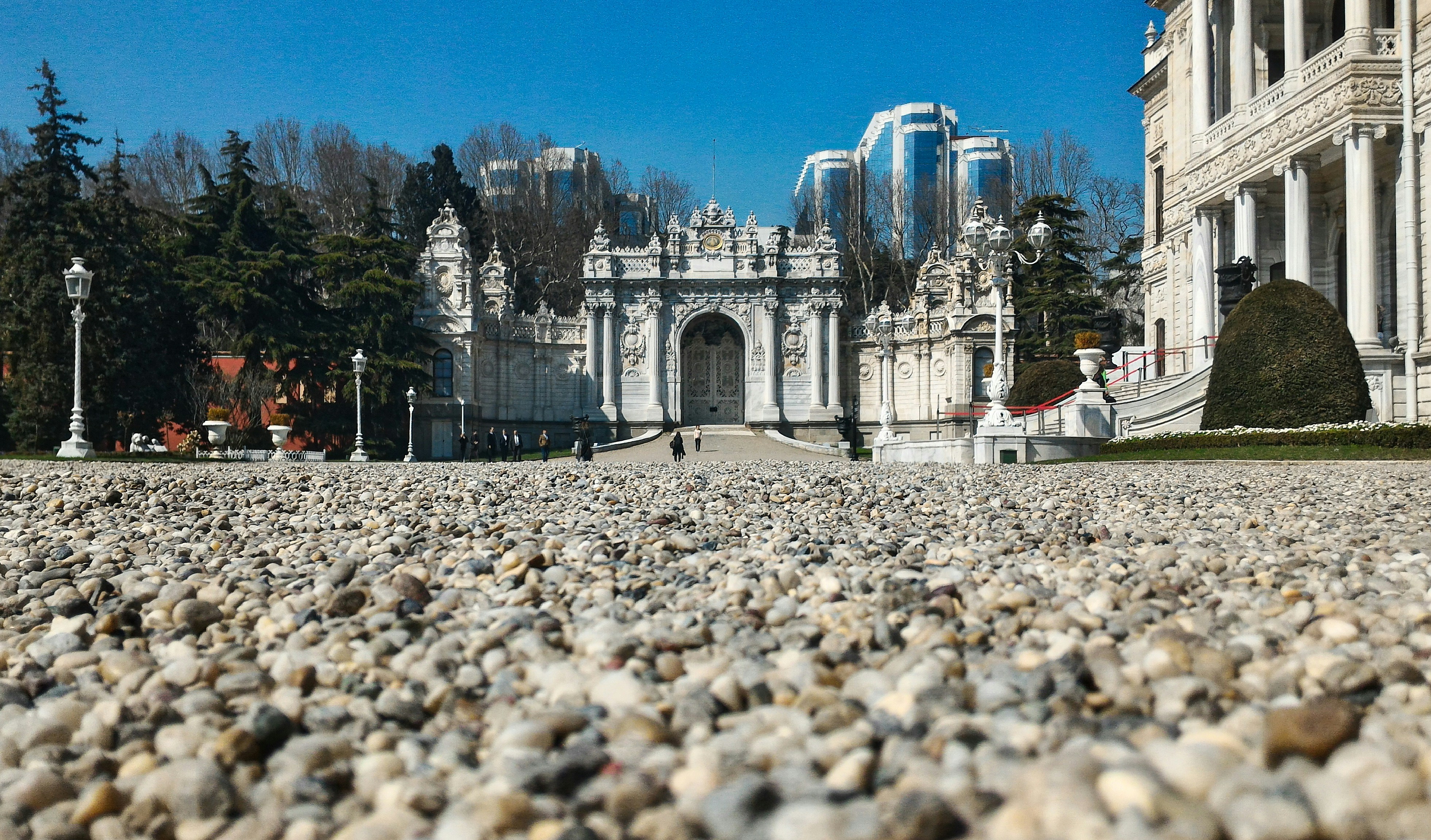 a large white building sitting on top of a lush green field