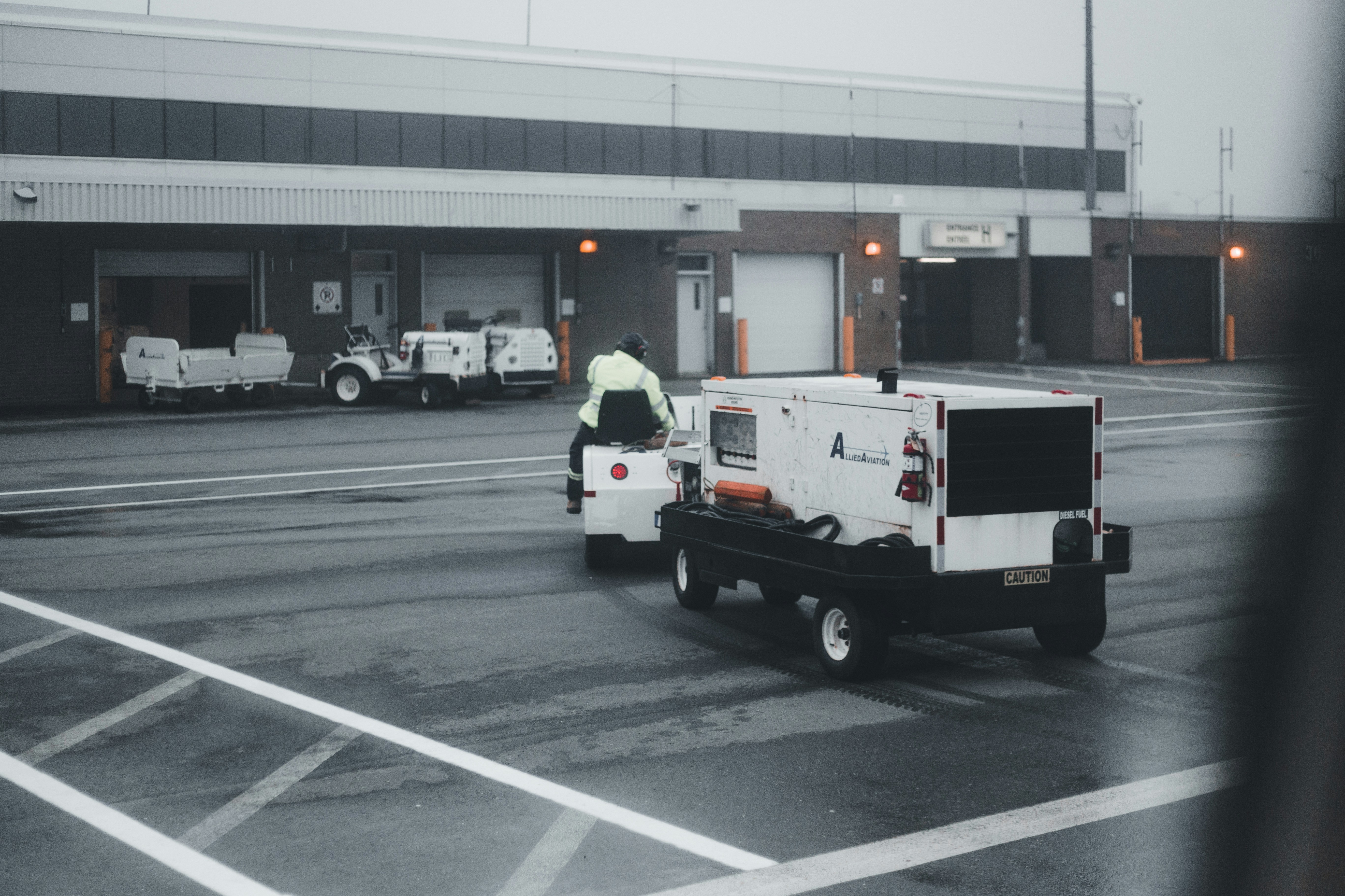 a man standing on the back of a truck in a parking lot