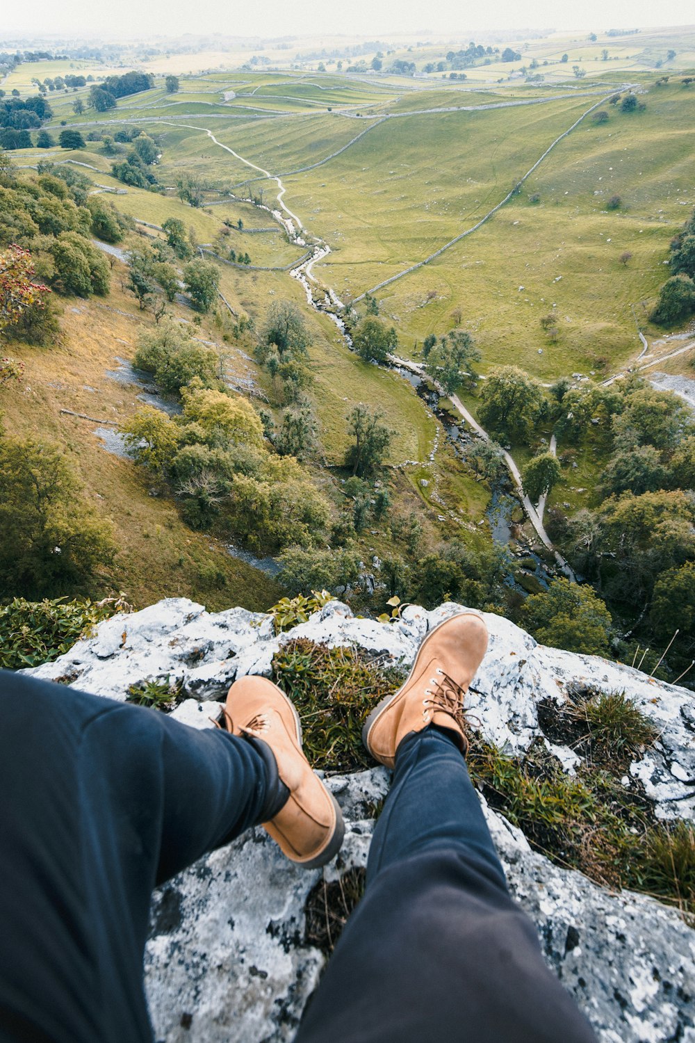 a person sitting on a rock overlooking a valley