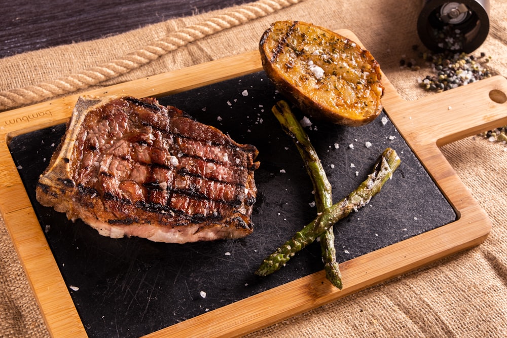 a steak and asparagus on a cutting board
