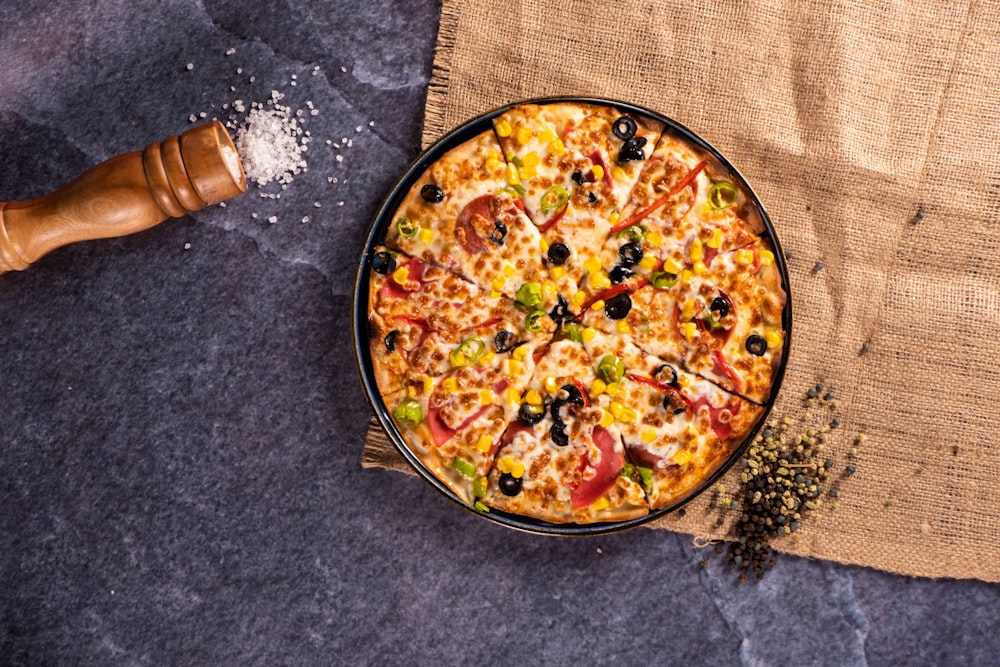 a pizza sitting on top of a table next to a wooden spatula