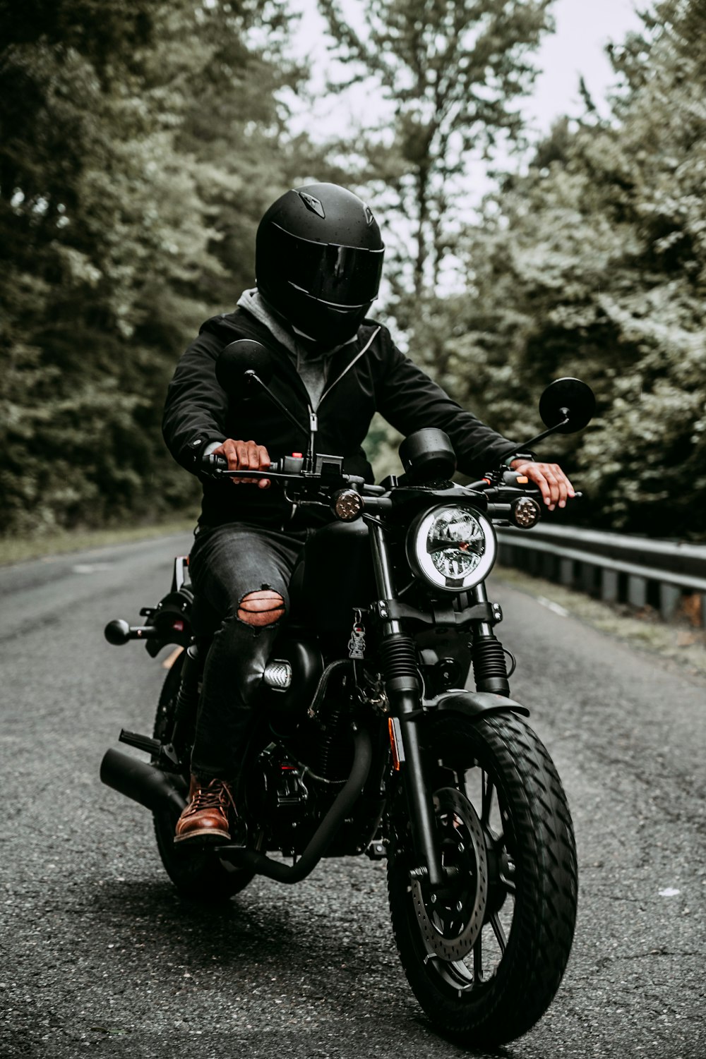 a man riding on the back of a motorcycle down a road