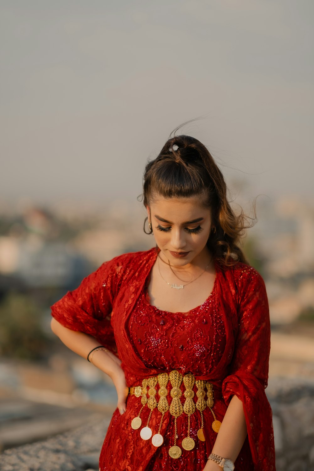 a woman wearing a red dress and a gold necklace