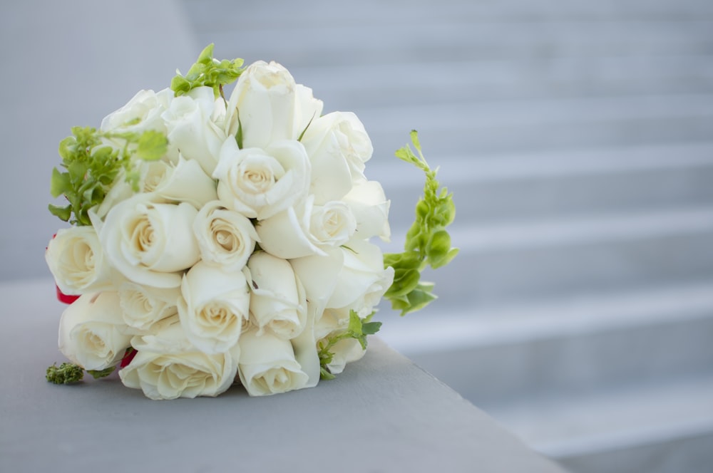 a bridal bouquet of white roses and greenery