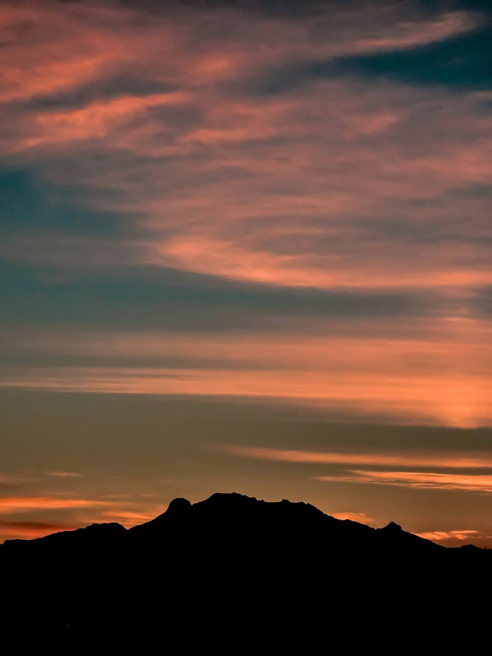 a plane flying in the sky with a sunset in the background