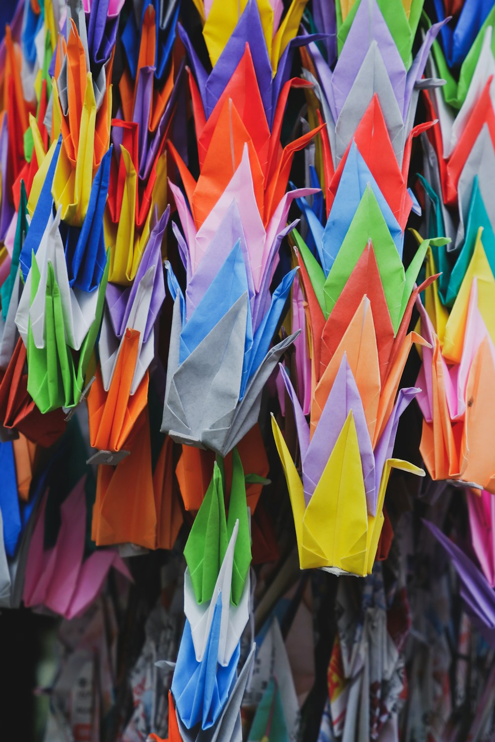 a bunch of colorful kites hanging from a pole
