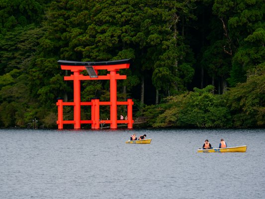 A group of people on small boats in a body of water — Hakone, Japan