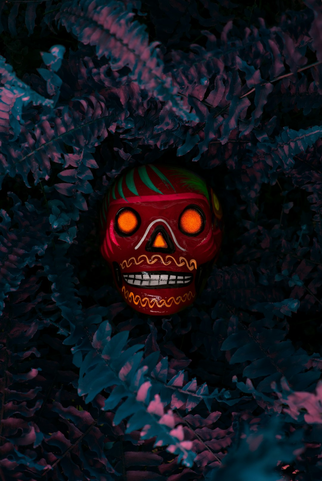 a red and green skull with glowing eyes