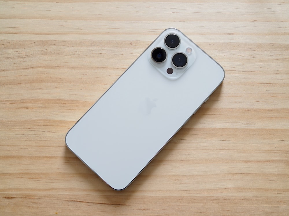 a close up of a cell phone on a wooden surface