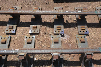 Industrial railway track with coated bolts securing the rails.