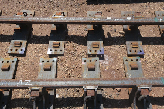 Industrial railway track with coated bolts securing the rails.